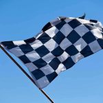 Heart Attack SUSPECTED in Racer’s Tragic Demise A checkered flag waving against a clear blue sky