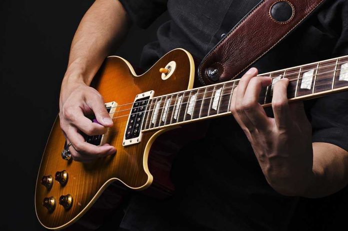 Close-up of a musicians hands playing an electric guitar