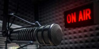 Radio microphone in studio with On Air sign.