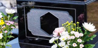 Colorful flowers on a black tombstone.