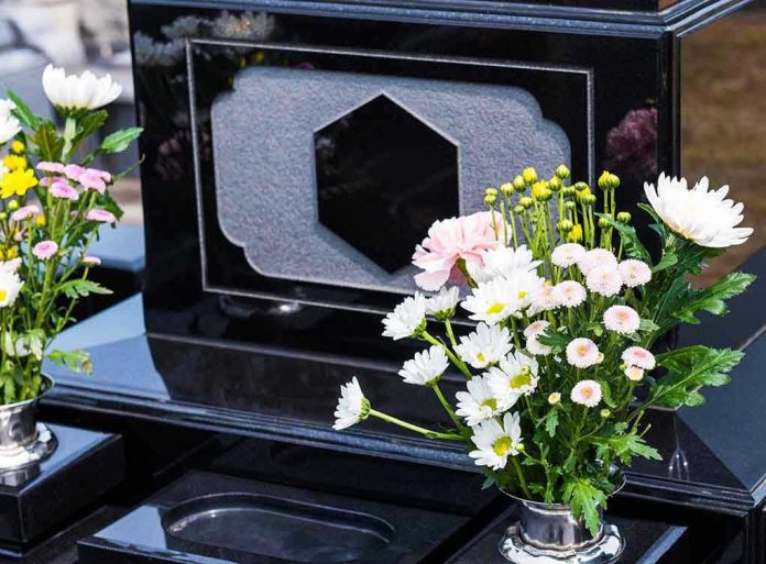 Colorful flowers on a black tombstone.
