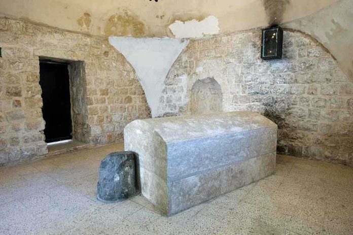 Interior of a historical site featuring a stone tomb and ancient walls
