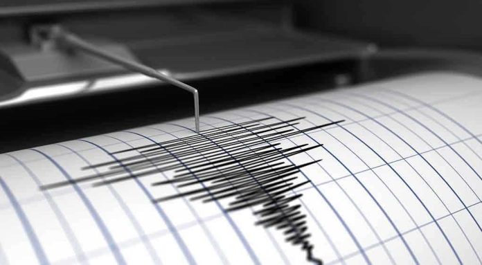 Seismograph needle recording earthquake activity on paper.