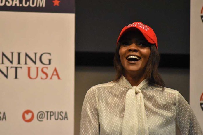 A woman wearing a red cap and a white blouse speaking at a political event