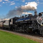 A vintage steam locomotive pulling passenger cars on a railway track