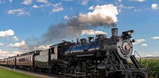 A vintage steam locomotive pulling passenger cars on a railway track