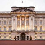 SHOCKING Breach — Royal Meets Chinese Spymaster Front view of Buckingham Palace with illuminated facade and British flag