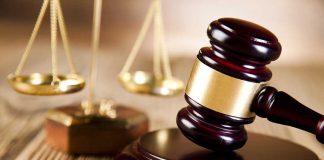 A wooden gavel and scales of justice on a table