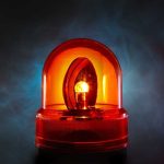 An illuminated orange emergency light on a dark background