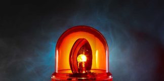 An illuminated orange emergency light on a dark background