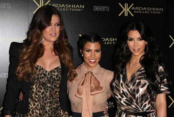 Three Kardashian sisters posing together at a fashion event