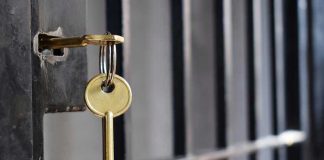 Key in lock of prison cell door.