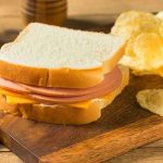 Ham and cheese sandwich with potato chips.