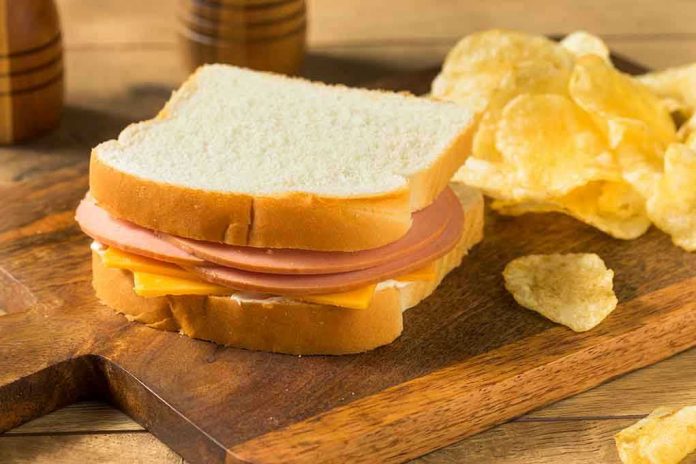 Ham and cheese sandwich with potato chips.