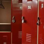 Red lockers with padlocks, one open with hanger.