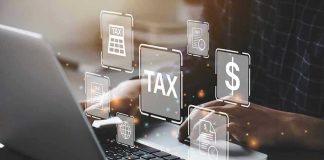 Person typing on laptop with tax-related icons displayed.