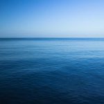 A calm ocean under a clear blue sky