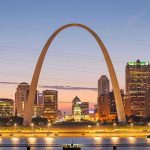 St. Louis Gateway Arch at sunset with cityscape.