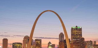 St. Louis Gateway Arch at sunset with cityscape.