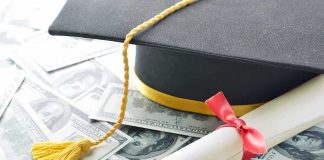 Graduation cap and diploma resting on a pile of money
