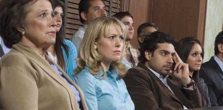 A group of jury members sitting in a courtroom with serious expressions