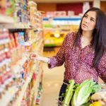 Facial Recognition Fury: Wegmans Sparks Outrage Woman shopping in a grocery store aisle with a cart full of vegetables