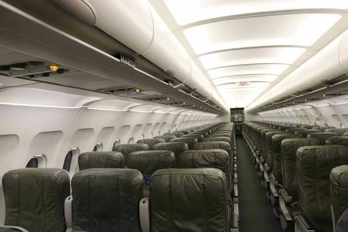 Empty airplane cabin with rows of green seats.