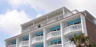Exterior view of a beachfront hotel with balconies and colorful towels hanging
