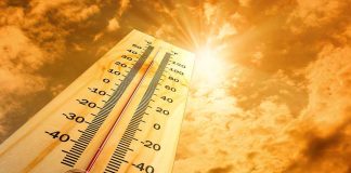 A thermometer displaying temperature against a sunset sky