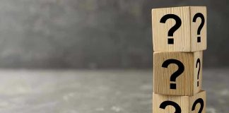 Three wooden blocks with question marks stacked.