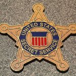Golden badge of the United States Secret Service displayed on a surface