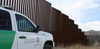 Air Fire Ends Million-Dollar Smuggle Border protection vehicle near a large metal fence.