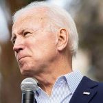 Privacy Shield Cracks — Biden Audio Coming Man holding microphone, looking to the side.