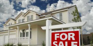 Housing Pain Explodes After Biden Border Wave A suburban house with a For Sale sign in the front yard