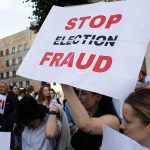 People holding Stop Election Fraud protest signs.