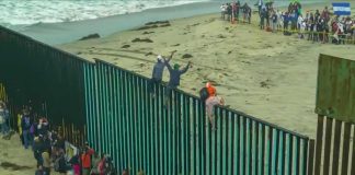 Border Meltdown in Spain’s Ceuta People climbing a tall beachside border fence
