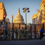 National Guard troops stand at a security fence near the U.S. Capitol