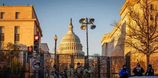 National Guard troops stand at a security fence near the U.S. Capitol