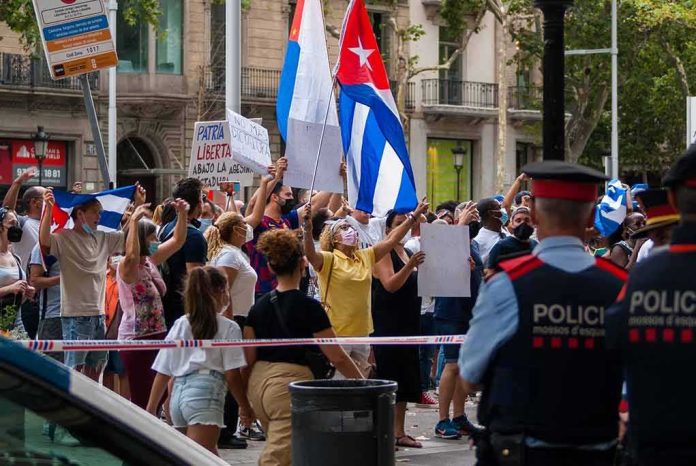 Crowd of protesters holding flags and signs behind police tape