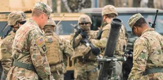 Iran Strike in Jordan Kills U.S. Troops Soldiers in camouflage gather around a mortar during field training