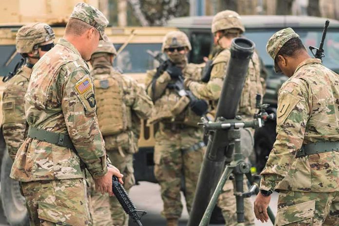 shutterstock_2141370335 Soldiers in camouflage gather around a mortar during field training