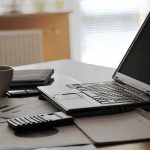 6G Sees Through Walls—Who’s Watching? laptop on desk with calculator and coffee mug