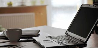 6G Sees Through Walls—Who’s Watching? laptop on desk with calculator and coffee mug