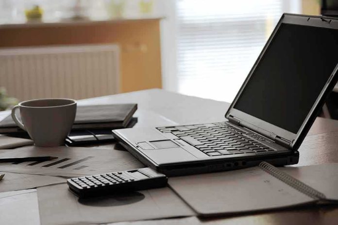 laptop on desk with calculator and coffee mug