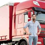 man standing in front of a red semi truck
