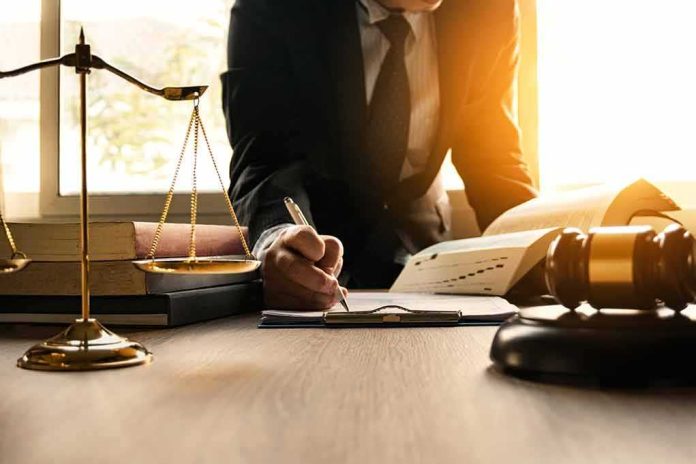 Lawyer writing at desk with scales and gavel