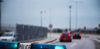 Police car with blue lights on near a roadway