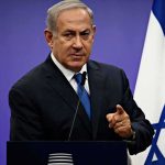 Netanyahu Drops Chilling Assassination Bombshell man in suit speaking at podium with Israeli flag