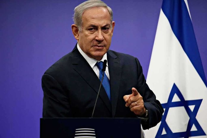shutterstock_1042782061-1 man in suit speaking at podium with Israeli flag