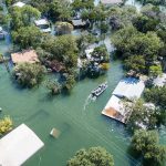 Aerial view of flooded neighborhood with rescue boat navigating streets